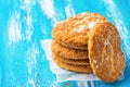 Stack of freshly home baked oatmeal and coconut cookies on parchment paper on blue wood kitchen table. Australian anzac biscuits Royalty Free Stock Photo