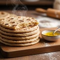 A stack of freshly made flatbreads, emitting steam, sits on a wooden cutting board. Th Royalty Free Stock Photo