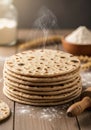 A stack of freshly made flatbreads is placed on a wooden surface, with flour scattered Royalty Free Stock Photo