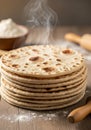 A stack of freshly made flatbreads, possibly tortillas or pita, sit steaming on a wooden Royalty Free Stock Photo