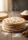 A stack of freshly made flatbreads, still steaming, sits on a wooden surface dusted Royalty Free Stock Photo