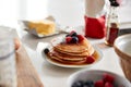 Stack Of Freshly Made Pancakes Or Crepes With Maple Syrup And Berries On Table For Pancake Day Royalty Free Stock Photo