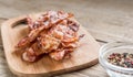 Stack of fried bacon strips on the wooden board Royalty Free Stock Photo