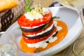 Stack of fried eggplant with tomatoes and piquant sauce