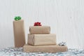 Stack of gifts in kraft paper with bow of green, red and silver colors. Plaster wall. Copy space, mock up Royalty Free Stock Photo