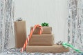 Stack of gifts in kraft paper with bow of green, red and silver colors. Tinsel on a white background Christmas candy cane. Plaster Royalty Free Stock Photo