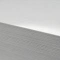 A stack of glossy white paper is viewed from the side showing a smooth Royalty Free Stock Photo