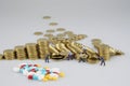 Stack of gold coin with miniature people and blur medicine Royalty Free Stock Photo