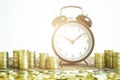 Stack Of Gold Coins With Black Fashioned Alarm Clock For Display