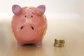 Stack of gold coins standing next to piggy bank Royalty Free Stock Photo