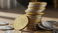 A stack of gold and silver coins is seen on a wooden surface Royalty Free Stock Photo