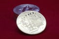 A stack of gold and silver cryptocurrency coins with bitcoin in the front on a red velvet background