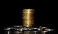 Stack of golden coins and heap of silver coins on a black background Royalty Free Stock Photo