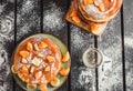 Stack of golden pancakes with bananas and oranges on wooden board covered with caster sugar top view Heap of american pancakes Royalty Free Stock Photo