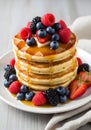 Stack of Golden Pancakes with Fresh Berries and Syrup Royalty Free Stock Photo