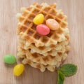 A stack golden waffle with candy.