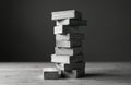 Stack of gray blocks on wooden surface represents stability, construction. Balanced blocks symbolize continuity, resilience, risk Royalty Free Stock Photo
