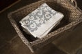 Stack of Gray Floral Design Napkins in Rectangular Woven Basket