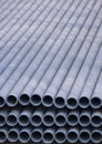 Stack of gray galvanized pipes material inside of construction site