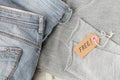 Stack of gray jeans and tag with inscription free