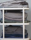 A stack of gray linen in various shades on a white plastic bedside table with a gray background.We wash the laundry Royalty Free Stock Photo