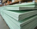 Stack of green plasterboard sheets for construction. Gypsum panels used for building walls, ceilings, partitions. Material in Royalty Free Stock Photo