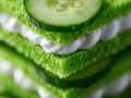 A stack of green sandwiches with cucumber slices on top Royalty Free Stock Photo