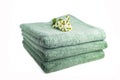 Stack of green, terry, bath towels isolated on white background