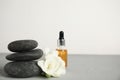 Stack of grey spa stones, flowers and oil on table, space for text Royalty Free Stock Photo