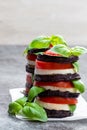 Stack of grilled eggplant with tomato and mozzarella on grey stone table Royalty Free Stock Photo