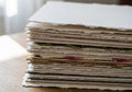 A stack of handmade paper rests on a wooden surface. The sheets Royalty Free Stock Photo