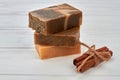 Stack of handmade soap blocks with cinnamon on white desk. Royalty Free Stock Photo