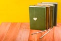 Stack of hardback books, diary on wooden deck table and yellow background. Back to school. Copy Space. Education Royalty Free Stock Photo