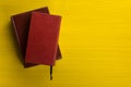 Stack of hardback books, diary on wooden deck table and yellow background. Back to school. Copy Space. Education Royalty Free Stock Photo