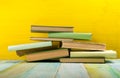 Stack of hardback books, diary on wooden deck table and yellow background. Back to school. Copy Space. Education Royalty Free Stock Photo