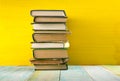 Stack of hardback books, diary on wooden deck table and yellow background. Back to school. Copy Space. Education Royalty Free Stock Photo