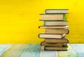 Stack of hardback books, diary on wooden deck table and yellow background. Back to school. Copy Space. Education Royalty Free Stock Photo