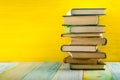 Stack of hardback books, diary on wooden deck table and yellow background. Back to school. Copy Space. Education Royalty Free Stock Photo