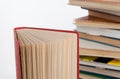 Stack of hardback books and old open book on white wall background. Search for relevant and necessary information. Royalty Free Stock Photo