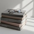 A stack of hardcover books with gray and neutral-toned covers is arranged on a white Royalty Free Stock Photo