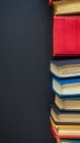 stack of hardcover books in a variety of colors against a dark background, forming a neat, vertical alignment on the Royalty Free Stock Photo