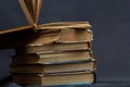 Stack of hardcover old books with an open book on a dark background. Bookshelf shop, Knowledge publications, literature. Bookish Royalty Free Stock Photo