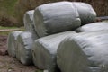 Stack of hay bales wrapped in plastic foil on a farm field Royalty Free Stock Photo