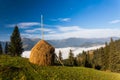 Stack of hay on a green meadow in the mountains Royalty Free Stock Photo