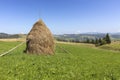 Stack of hay on a mountain meadow on a hillside.