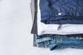 Stack Heap of Folded Jeans Cotton Pants and Shirts on White Wood Background Shelf Closet. Eco Fashion Authentic Classic Style