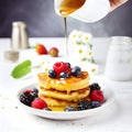 A stack of home made cottage cheese pancakes with honey, blueberry and strawberries and other berries on a light gray background, Royalty Free Stock Photo