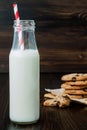 Stack of homemade chocolate chip cookies with milk on dark wooden table. Copy space background Royalty Free Stock Photo