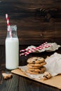 Stack of homemade chocolate chip cookies with milk on dark wooden table. Copy space background Royalty Free Stock Photo