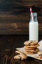 Stack of homemade chocolate chip cookies with milk on dark wooden table. Copy space background Royalty Free Stock Photo